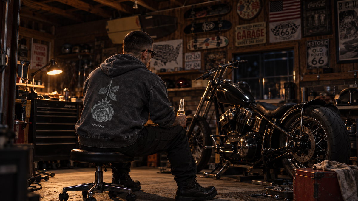 Back view of BLACK ROSE Hoodie beside a motorcycle in a garage.