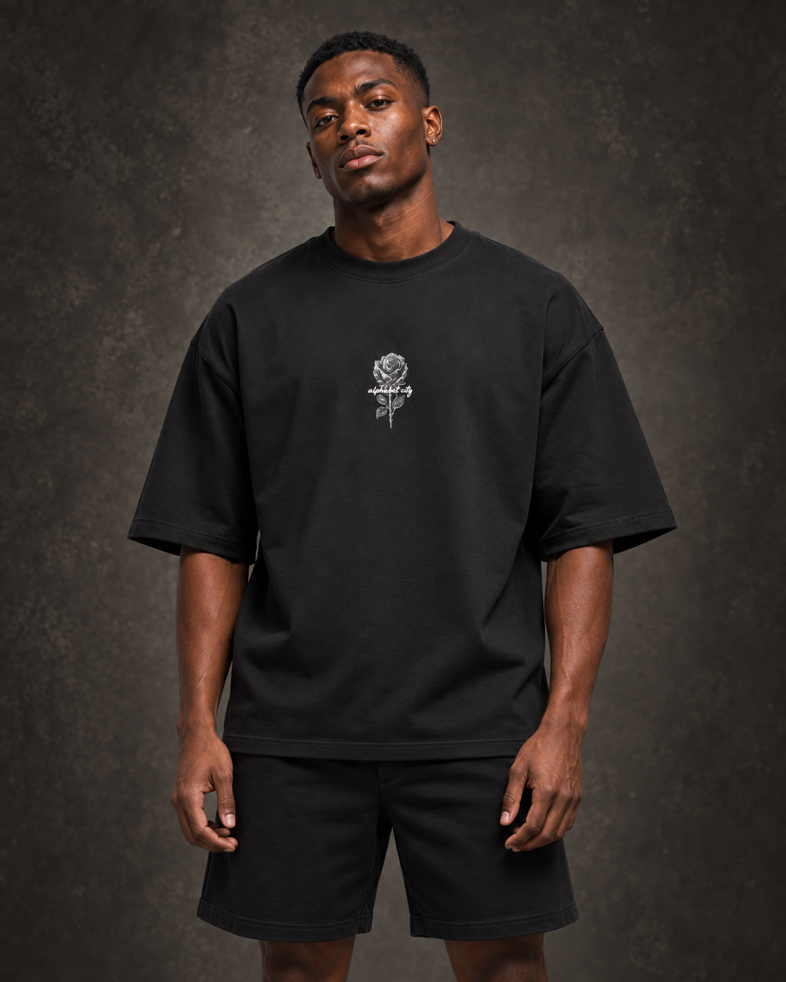 Studio styling image of Malik wearing BLACK ROSE Tee, front view.