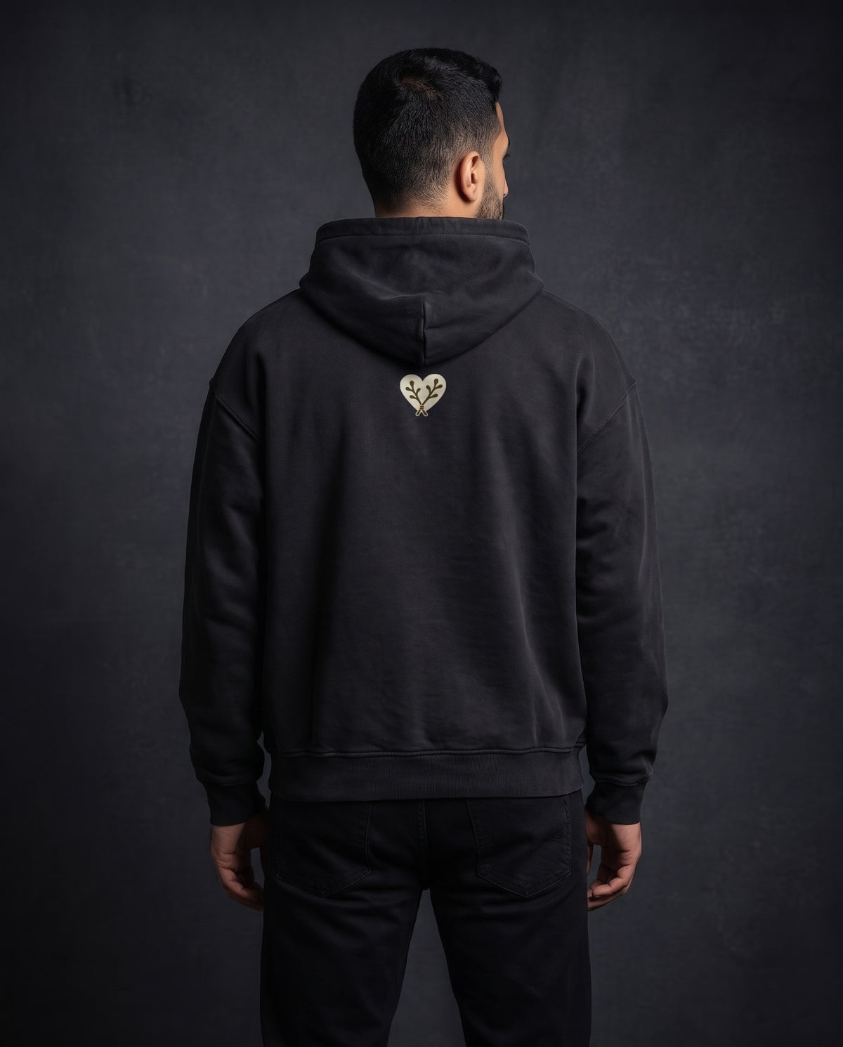 Model wearing the Heart Heavyweight Pullover Hoodie in Faded Black, back view