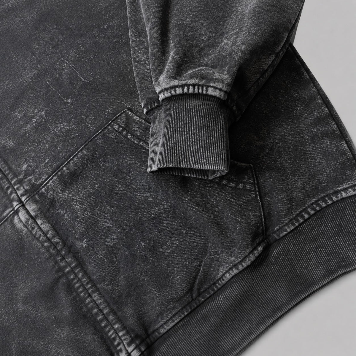 Close-up of the BLACK ROSE Hoodie's ribbed cuff, kangaroo pocket and snow-wash fabric.